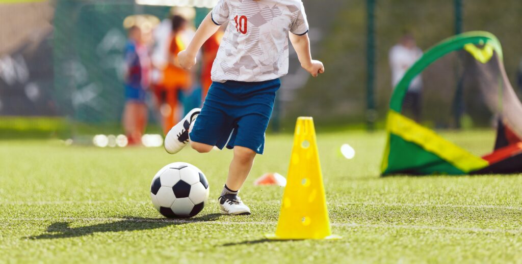 A young boy kicking a football